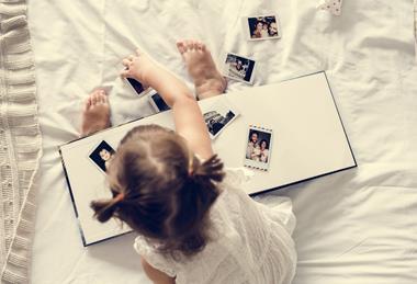 pp41_April2024_MothersOfDaughters_little-girl-playing-with-a-photo-album-2023-11-27-05-32-01-utc