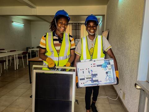 Winner (left) with a classmate outside a lab carrying tools